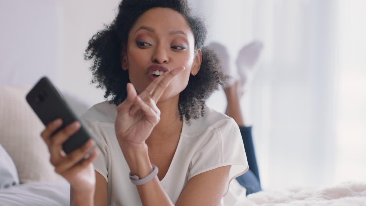 hermosa mujer tomando fotos de selfie usando un teléfono inteligente disfrutando de compartir su estilo de vida en las redes sociales acostada en la cama en casa