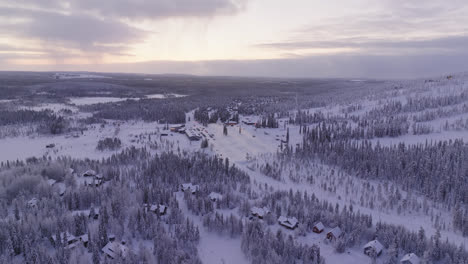 aerial view circling toward the parking lot under the slopes of iso-syote, winter in finland