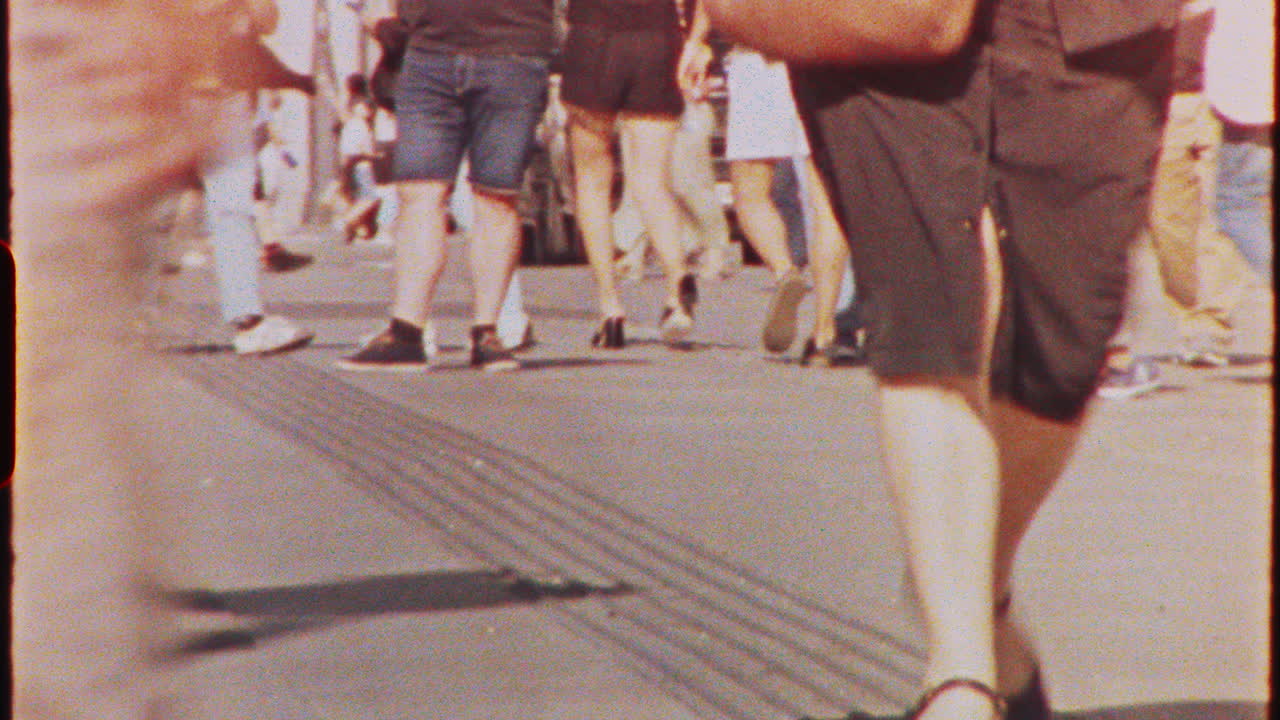 Timelapse - diverse crowd of tourists walking along bustling summer city street, capturing vibrant urban energy and dynamic pedestrian movement during daytime, 8 mm film timelapse