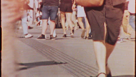 timelapse - diverse crowd of tourists walking along bustling summer city street, capturing vibrant urban energy and dynamic pedestrian movement during daytime, 8 mm film timelapse