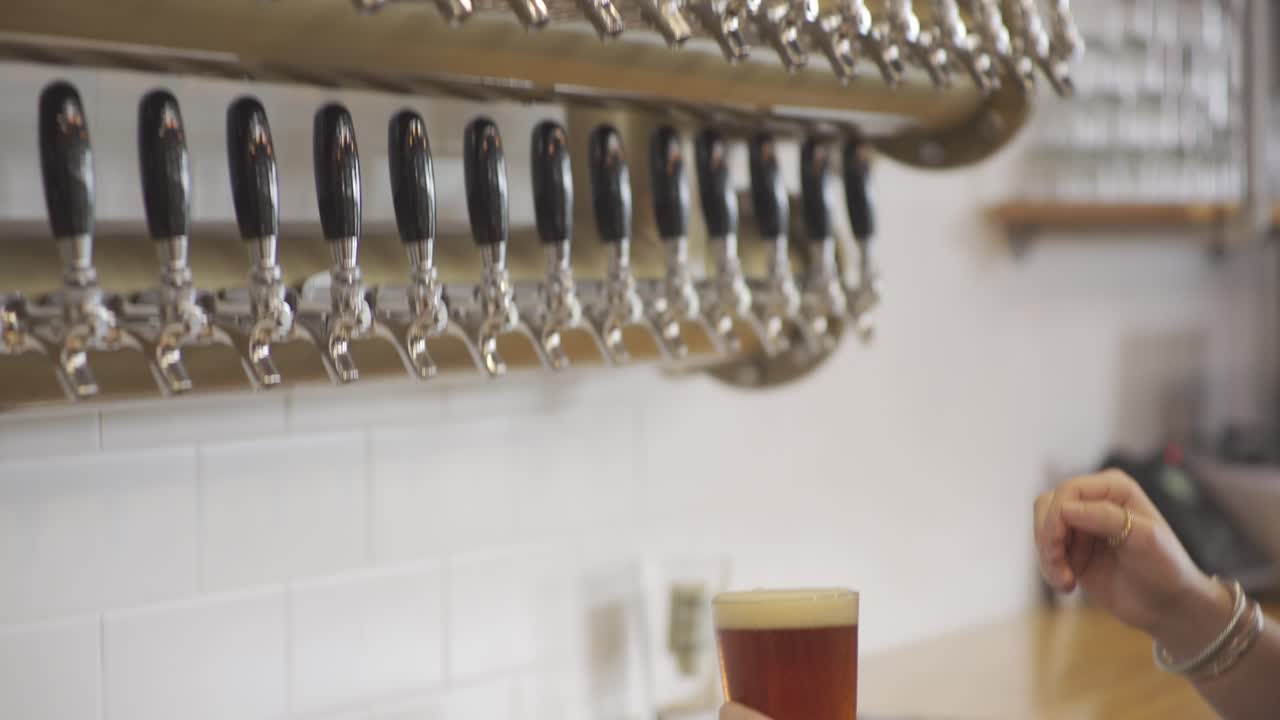 el camarero vierte un vaso de cerveza de un grifo en 4k 24fps