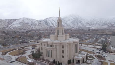 beautiful aerial view of a mormon temple in utah with hills covered in snow