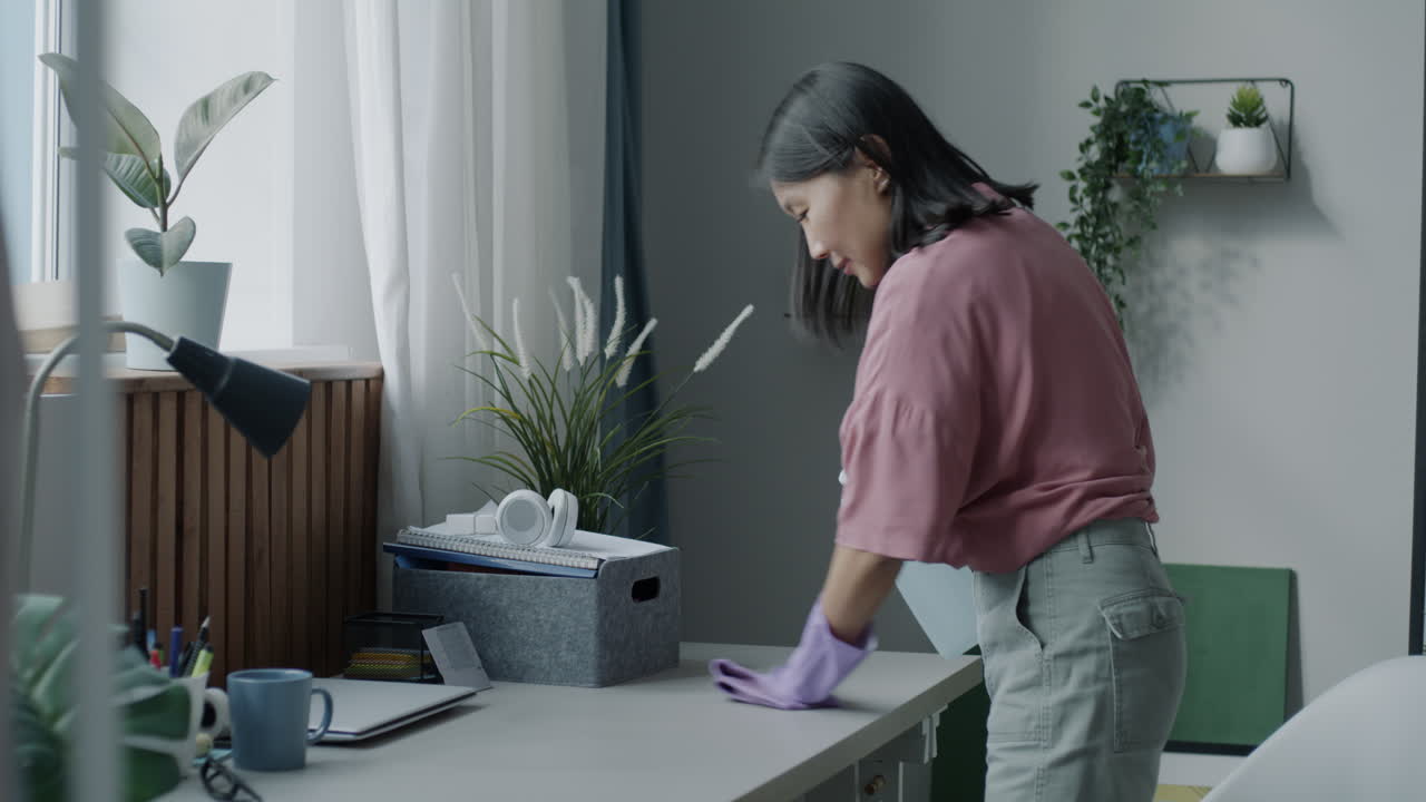 Woman cleaning her home office desk