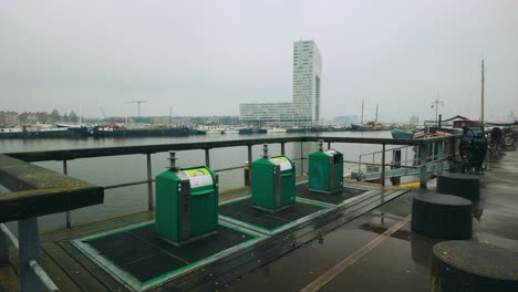 recycle bins in amsterdam houthaven harbor next to water residential area