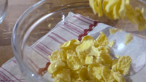 flocos de maíz amarillos crujientes en el cuenco para la mañana un delicioso desayuno con leche. cámara lenta con toma de seguimiento de rotación.
