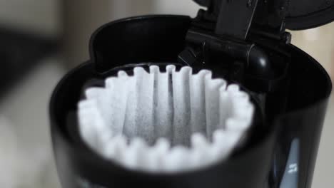 Placing-coffee-filter-in-coffee-maker-close-up