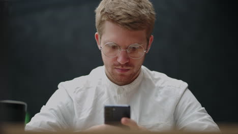 Usando-Internet-Por-Teléfono-Inteligente-Retrato-De-Un-Apuesto-Hombre-Europeo-Con-Camisa-Blanca-Y-Teléfono-Móvil-En-Las-Manos