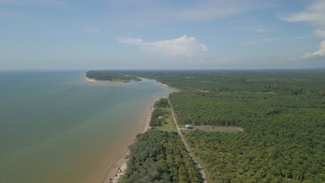 aerial drone view during summer alit fishing village,kabong with, facing open blue sea, white sandy beach,green coconut, palm trees,and river,sarawak,borneo