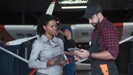 woman and mechanic discussing airplane maintenance