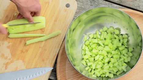 slicing cucumber on a cutting board for salad dish stock footage