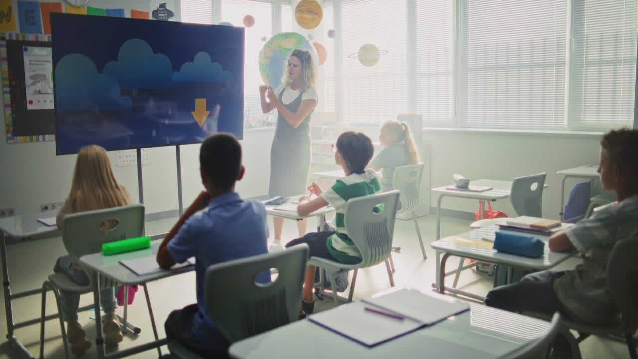 Geography Class Female Teacher Teaching Primary School Children Using Digital Screen