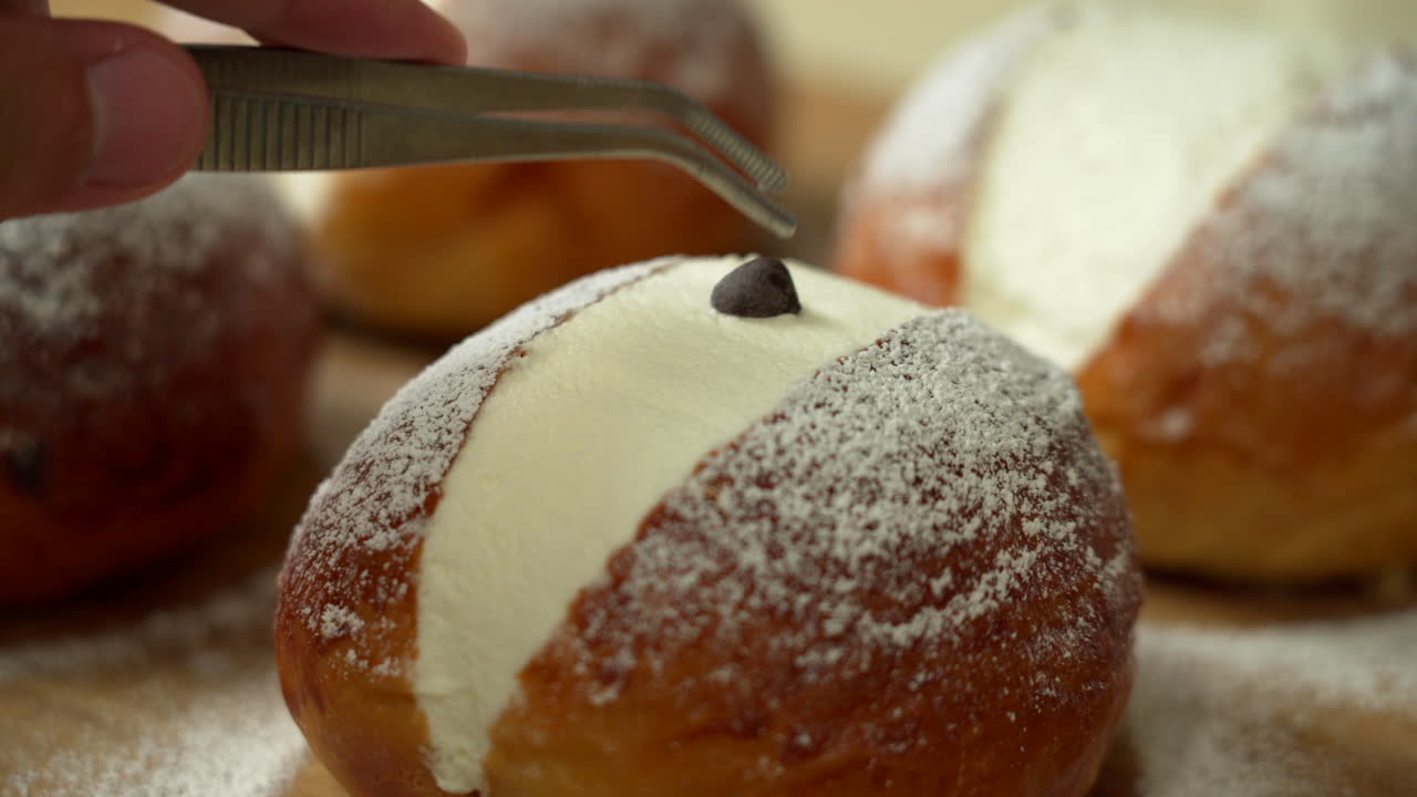 el panadero está preparando un pastel colocando una chispa de chocolate en el centro de un pastel