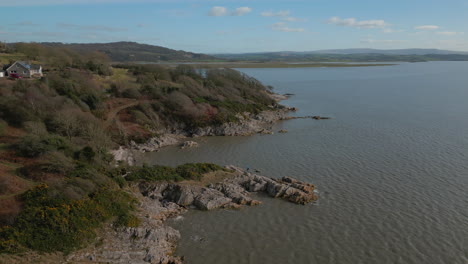 high view of hiker on rocky outcrop with ocean reveal at jenny brown's point silverdale uk