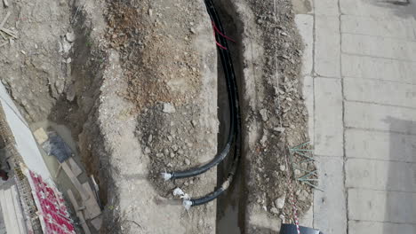 pipeline cables laid down in a dug out ditch at a construction site