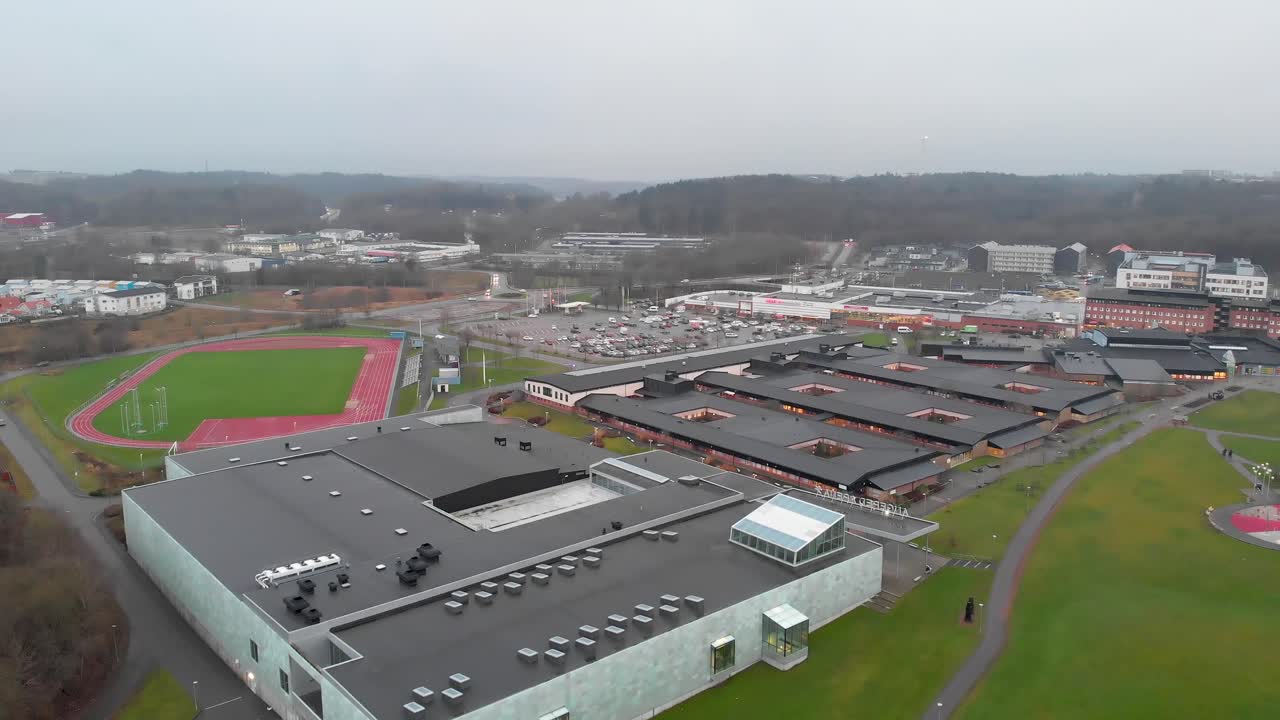 Complesso di edilizia popolare circondato da erba con persone che camminano su un sentiero ad Angered, Göteborg, Svezia.