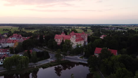 View-of-historic-town-with-14th-century-palace,-old-tenements,-pond