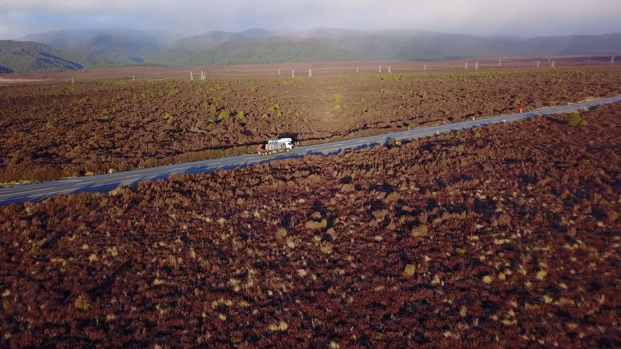 toma aérea de un dron de un rv moviéndose en llanuras cubiertas de hierba