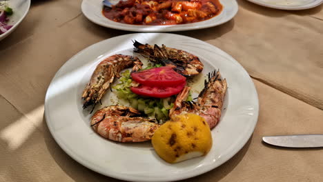 roasted tiger prawns in white plate, moving forward view