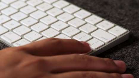 primer plano de manos latinas masculinas escribiendo rápido en un teclado, presionando retorno, presionando enter