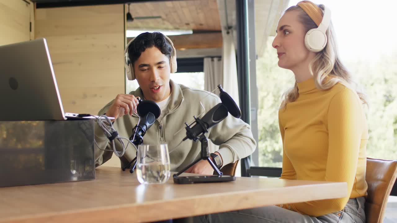 マイクに向かって話す様々なポッドキャストの共同ホスト、スタジオで女性が頷いている間、男性が手を挙げている様子