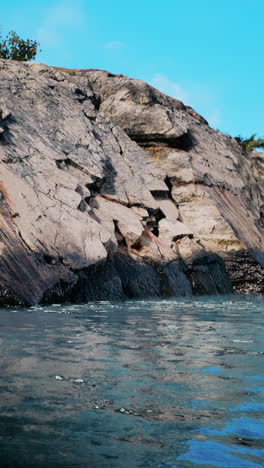 rocky cliff overlooking calm blue water