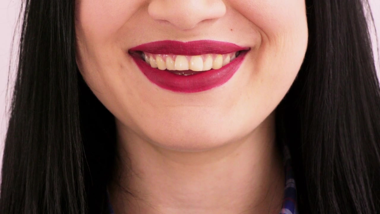 Close-up of a Woman Smiling with Dark Red Lipstick