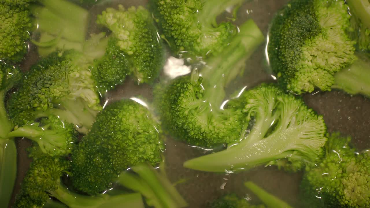 Fresh broccoli florets in a bowl of water