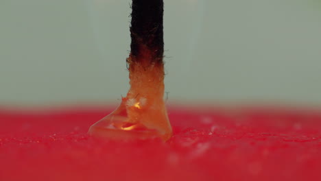 time lapse: macro studio view of yellow candle wax bubbling and melting down into red wax