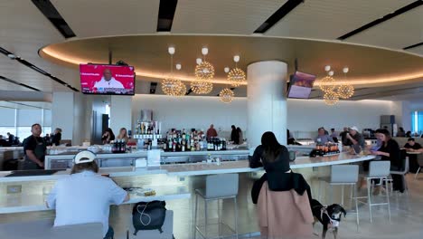 people enjoying drinks and waiting at a modern airport lounge bar