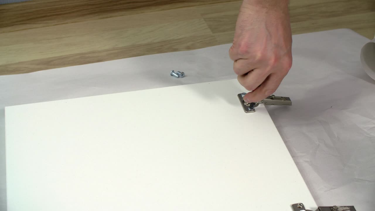 Cropped view of handyman installing loop screw on cupboard door