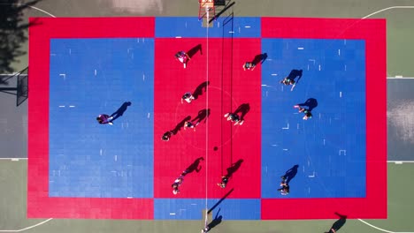playing volleyball on outdoor open court on sunny summer day, top down drone shot