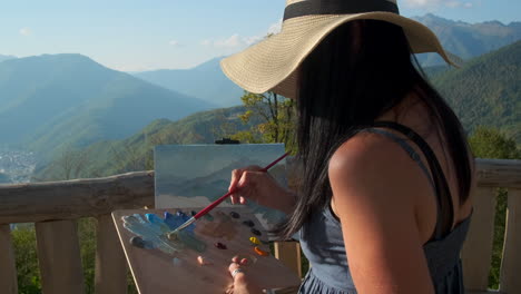 woman painting scenic mountain view