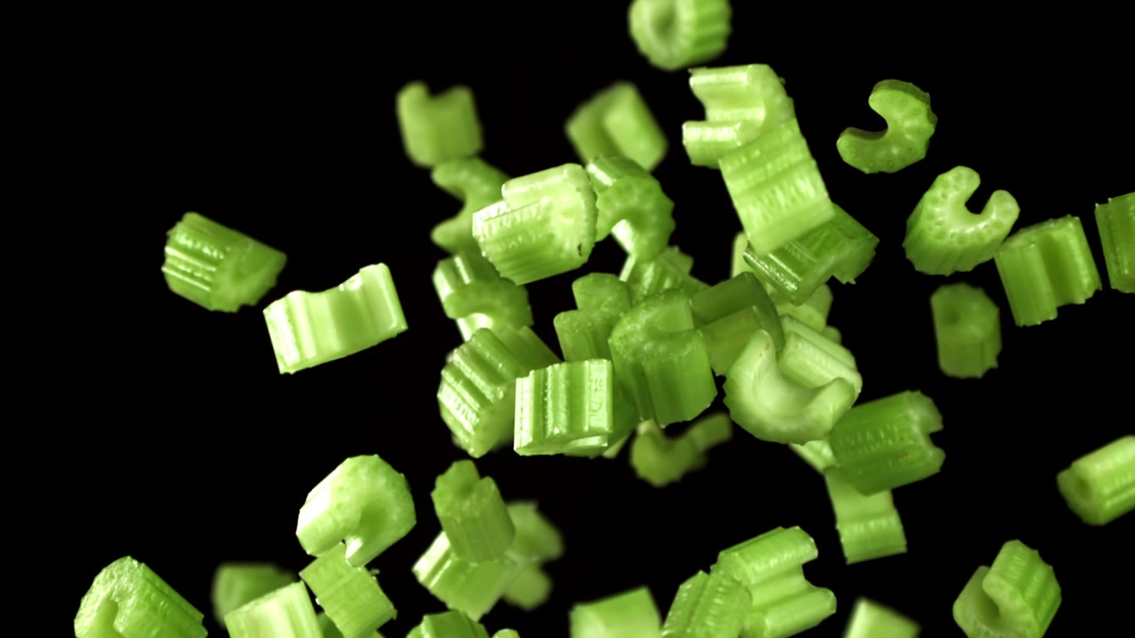 Chopped Green Celery Pieces Falling in Slow Motion