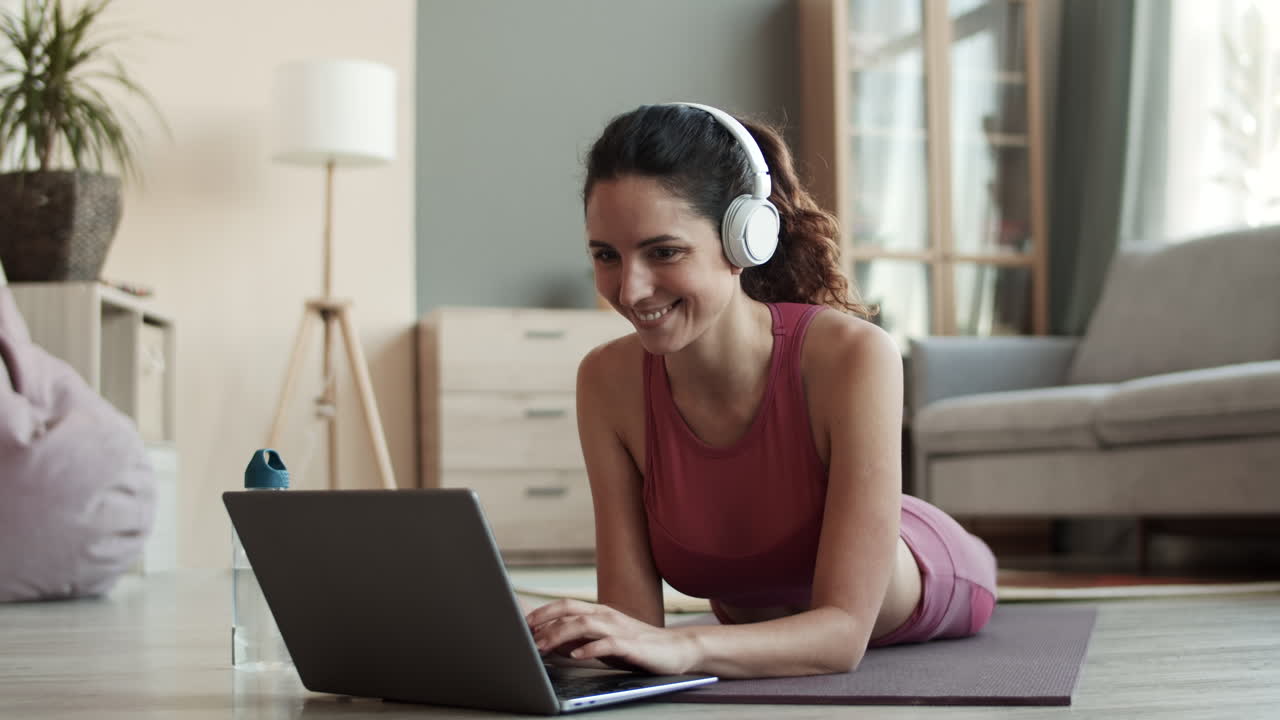 mujer deportiva escribiendo en una computadora portátil