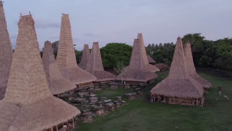 Drone-flies-over-traditional-village-close-to-roof-at-Sumba-island,-aerial