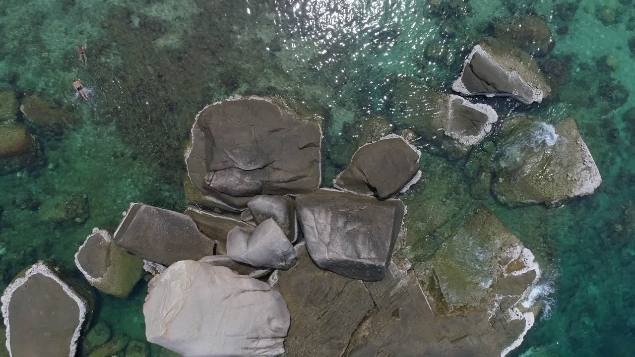 взгляд с воздуха на скалы в кристально чистой голубой воде