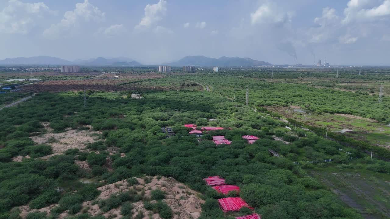 Drone footage of a serene rural landscape with mountains in the distance.
