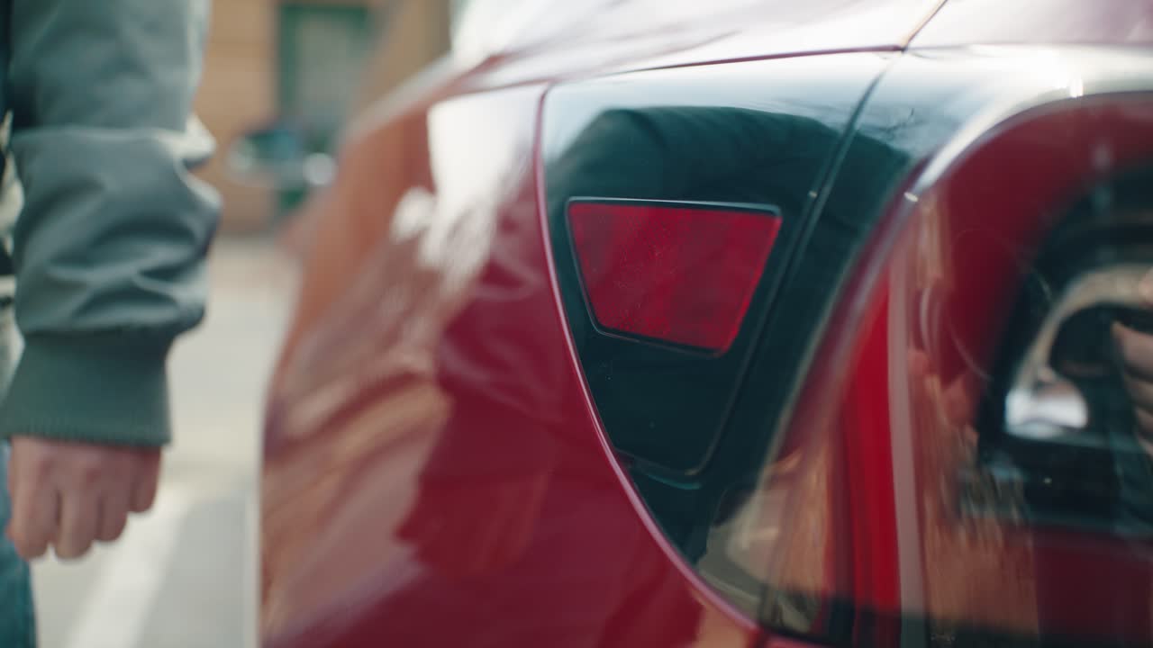 Close-up of opening the charging connection flap of the electric car