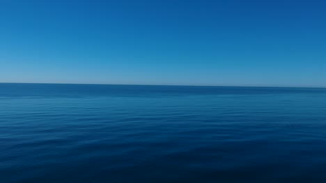 Background-of-a-tranquil-calm-ocean-and-windless-blue-sky