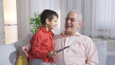 Father-and-son-are-laughing-and-looking-at-something-fun-on-the-phone.