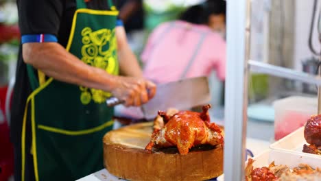 chef skillfully chops roasted chicken at market