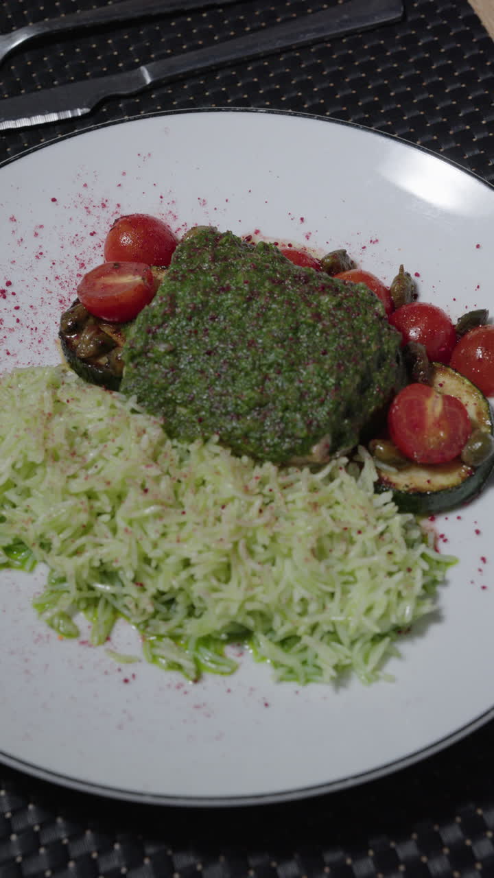 Gourmet dish with rice, pesto, and vegetables