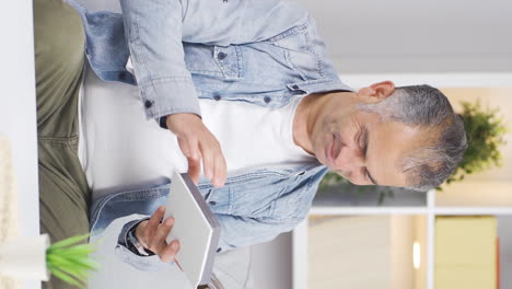 Vertical-video-of-The-man-looking-at-the-family-album-is-depressed.