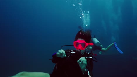 scuba divers exploring the deep blue underwater world