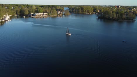 yacht sailing on beautiful lake galve in trakai, lithuania, during spring. drone aerial view