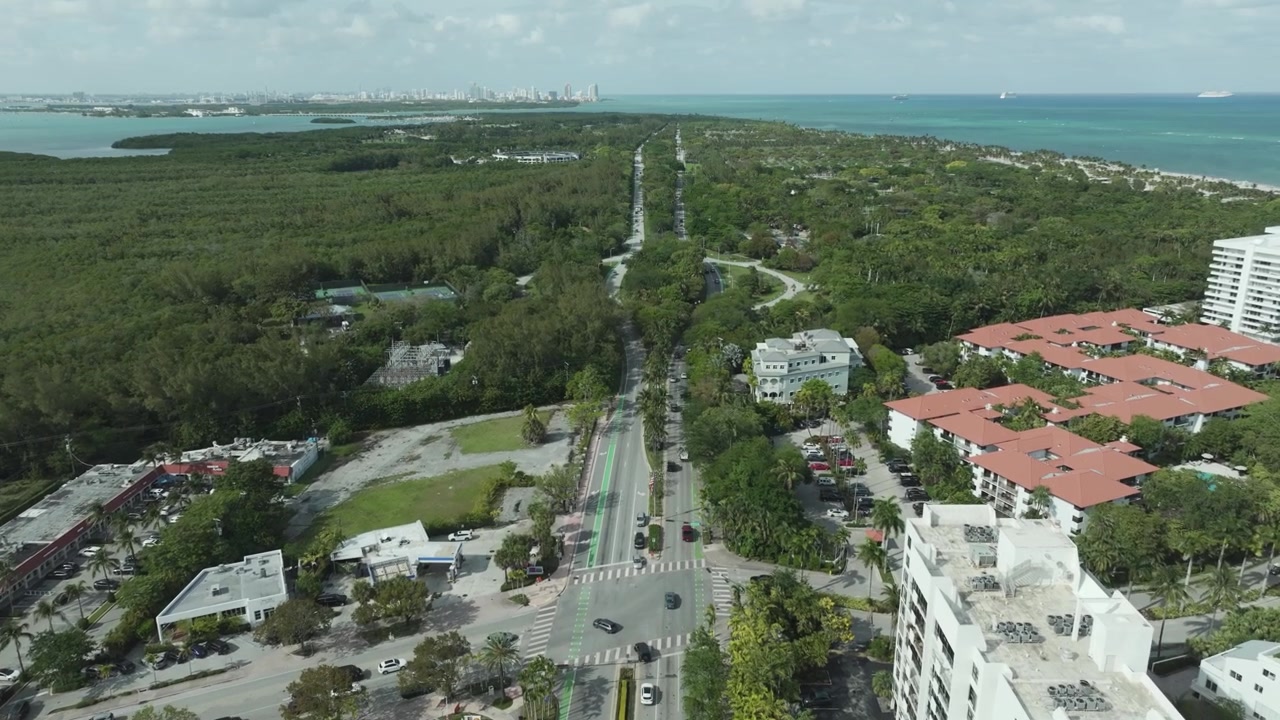 Riprese con drone di Key Biscayne, Florida, con rigogliose mangrovie, strade tortuose e lo skyline di Miami in lontananza che si erge oltre la baia