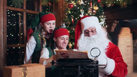 santa claus and elves in the residence read letters from children. new year's decorations in santa's residence