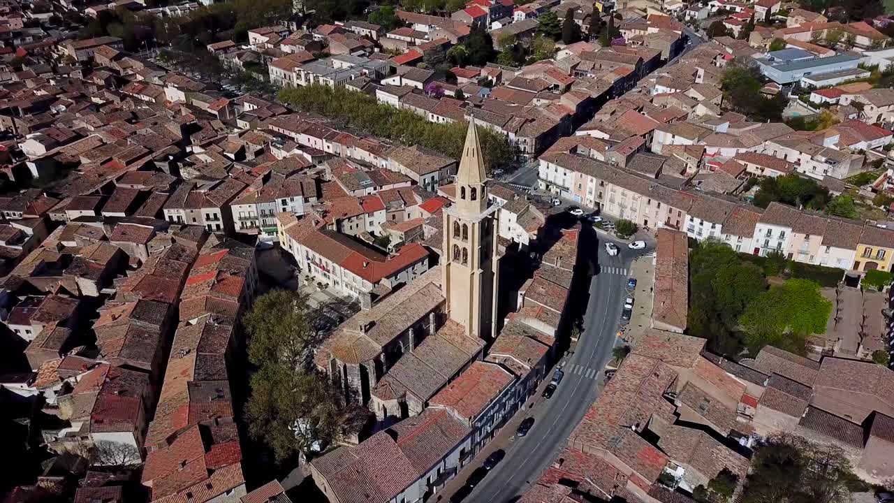 La chiesa al centro della città è ripresa dall'alto, rivelando i tetti degli edifici circostanti.