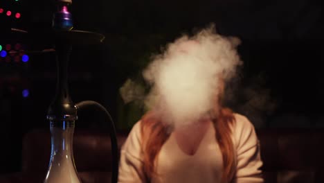 woman smoking hookah at night