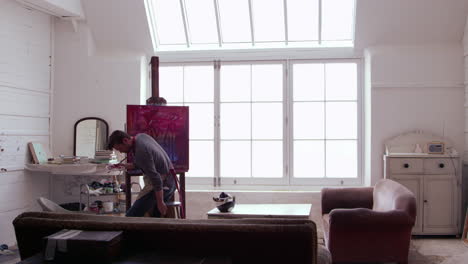 male artist works on painting in daylight studio shot on r3d